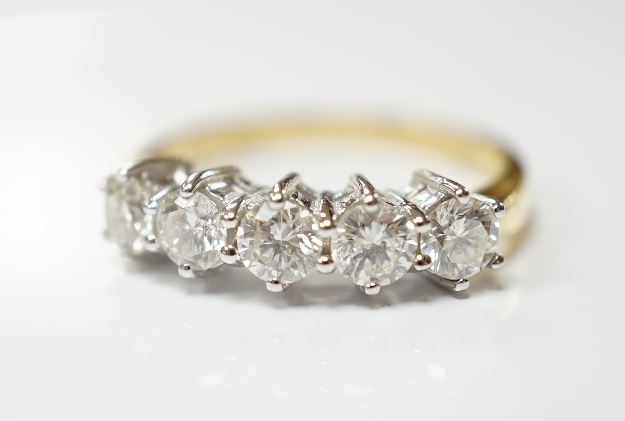 A modern 18ct gold and five stone diamond set half hoop ring, size N, gross weight 4 grams.